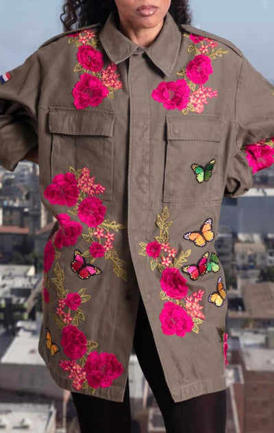 Female models front of CdJ Flower Bomb jacket, khaki-coloured military jacket with pink embroidered flowers and butterfly appliques.