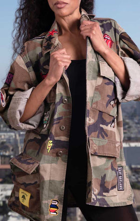 Load image into Gallery viewer, Female models front view of CdJ Rockstar jacket in camo print.
