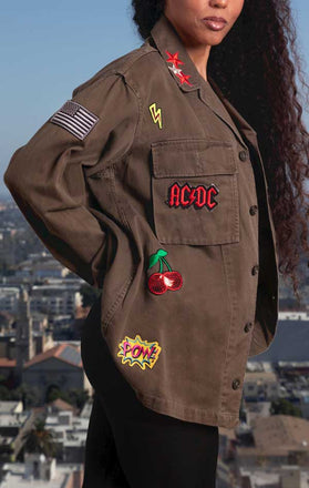 Load image into Gallery viewer, Female models side view of CdJ RockStar jacket in solid khaki with music patch embellishments.
