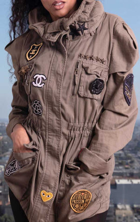 Load image into Gallery viewer, Female models front view of CdJ Special Order jacket in solid khaki with patch embellishments.
